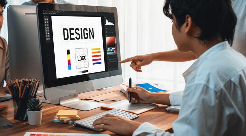 An instructor guiding a student through Adobe design tools