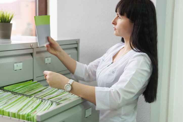 A medical office assistant organizing patient records and files