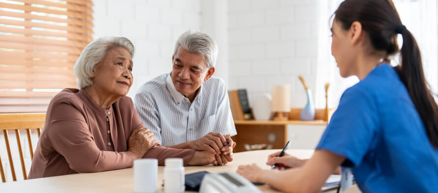 A medical office assistant interacting with elderly patients in a healthcare setting
